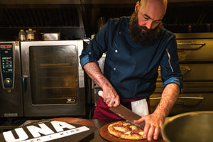 Chef cutting pizza wearing functional Indie chef jacket